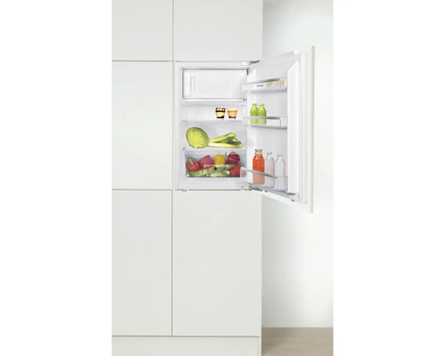 Réfrigérateur intégré avec porte ouverte, rempli de nourriture.