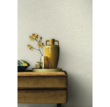 Scène avec un fond de mur beige, un canapé en velours beige, un plateau, des vases et une fleur