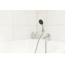 Salle de bains avec robinetterie apparente, douchette et flacons de shampooing