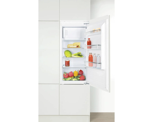 Geöffneter Kühlschrank mit Lebensmitteln in einer weißen Küche