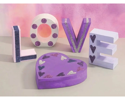 Dekorative Buchstaben und eine herzförmige Schachtel bilden das Wort Liebe