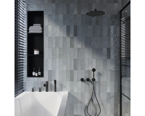 Salle de bains moderne avec baignoire, carreaux muraux gris, douche à effet pluie et étagère intégrée