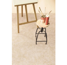 Detailansicht eines hellen Teppichbodens im Atelier mit Staffelei, Hocker und Malutensilien.