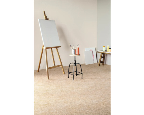 Szene mit einer Staffelei, einer Leinwand, einem Hocker, Pinseln, Farben und einem kleinen Tisch in einem hellen Raum.