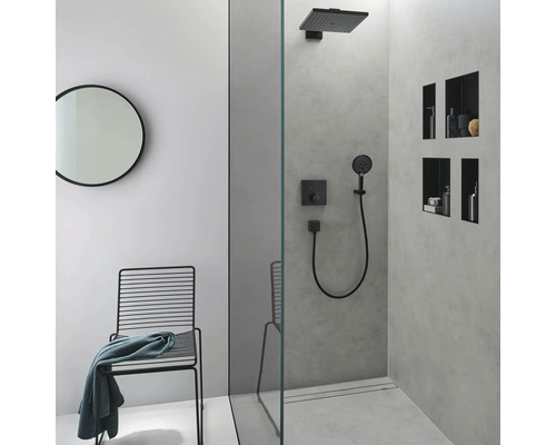 Salle de bains moderne avec douche, robinetterie noire, miroir rond et chaise