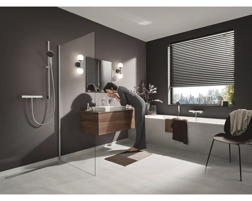 Salle de bains avec douche, lavabo, baignoire et store de fenêtre