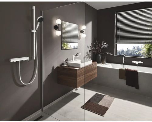 Salle de bain lumineuse avec douche, meuble sous-lavabo, baignoire et fenêtre