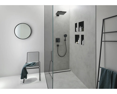 Modernes Badezimmer mit Dusche, rundem Spiegel und schwarzem Stuhl mit Handtuch