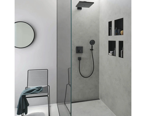 Modernes Badezimmer mit Dusche, Stuhl und rundem Spiegel