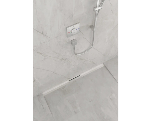 Begehbare Dusche mit Duschrinne, Duscharmatur und Handbrause vor hellgrauer Marmorwand