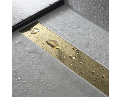 Aufsicht einer goldenen Duschrinne mit Wassertropfen