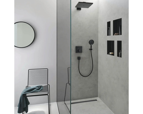 Modernes Badezimmer mit Dusche, schwarzer Armatur, rundem Spiegel und Metallstuhl