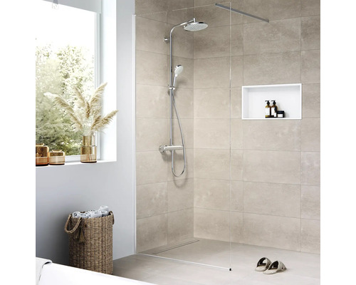 Douche à l''italienne avec robinetterie de douche, niche intégrée, serviettes et décoration dans une salle de bains lumineuse
