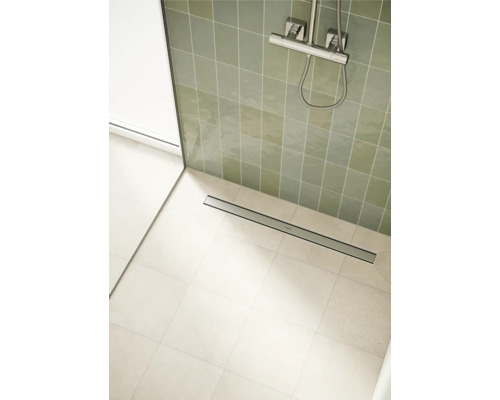 Salle de bains avec caniveau de douche, carrelage et robinetterie de douche