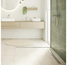 Badezimmer mit Waschtisch, Spiegel, Dusche und Badteppich