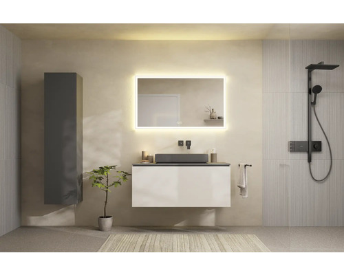 Helles Badezimmer mit Waschtisch, beleuchtetem Spiegel, Dusche und Handtuch