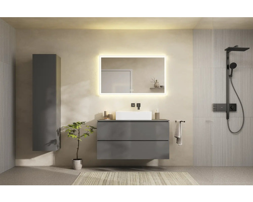 Badezimmer mit Waschtisch, beleuchtetem Spiegel, Hochschrank und Dusche