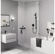 Badezimmer mit Badewanne, Dusche, Waschbecken, Spiegelschrank und Handtüchern