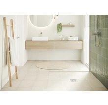 Salle de bain lumineuse avec lavabo, miroir, échelle porte-serviettes et douche