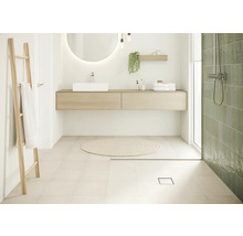 Salle de bain lumineuse avec lavabo, miroir, échelle à serviettes et douche