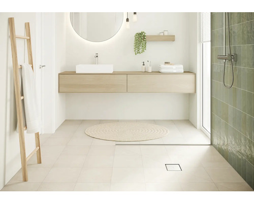 Salle de bain lumineuse avec lavabo, miroir, échelle à serviettes et douche