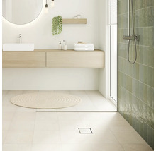 Salle de bains lumineuse avec lavabo, miroir, douche et caniveau de douche