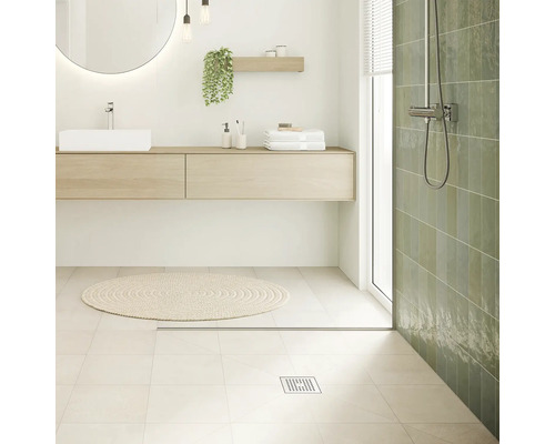 Salle de bain lumineuse avec lavabo, miroir, douche et tapis de bain