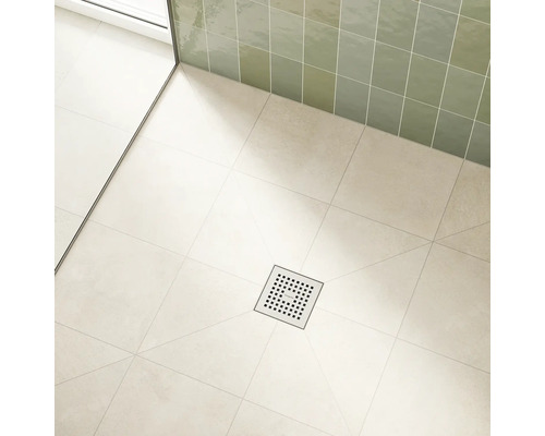 Espace de douche avec drain de sol carré en métal et carrelage