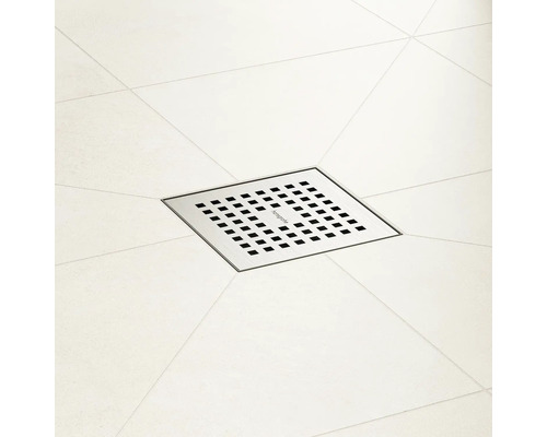 Évacuation de douche carrée en métal avec trous sur carrelage