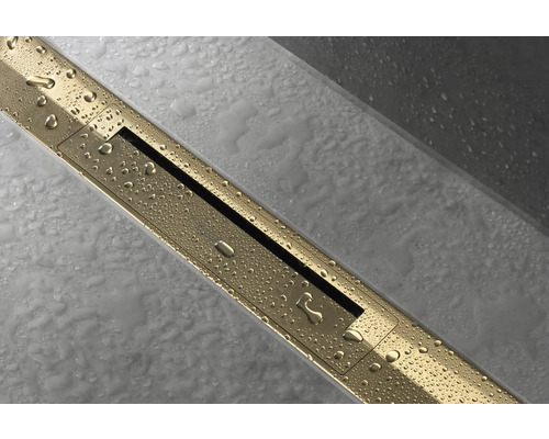 Goldene Duschrinne mit Wasserperlen auf hellgrauem Fliesenboden