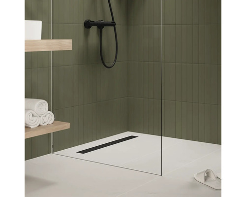 Salle de bains moderne avec douche, caniveau de douche, serviettes et étagères.