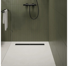 Badezimmer mit Dusche, schwarzer Duschrinne und grünen Fliesen.