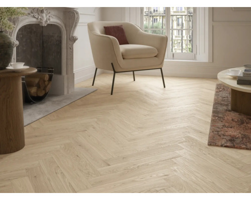 Wohnzimmer mit Kamin, Sessel und hellem Parkettboden im Fischgrätmuster