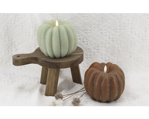 Dekorative Kürbis Kerzen auf einem Holzschemel