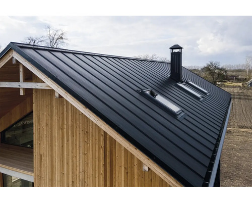 Maison avec toit métallique, fenêtres de toit et cheminée
