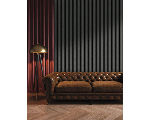 Salon avec canapé en cuir marron, lampadaire et panneaux muraux