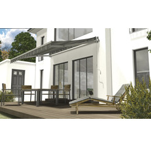 Hausfassade mit Markise, Terrassenmöbeln und Liegestuhl auf Holzterrasse