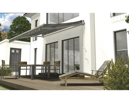 Façade de maison avec store, table de jardin et chaise longue sur terrasse en bois