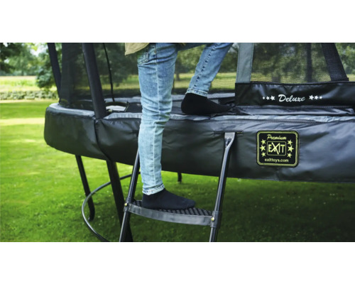 Person steigt über eine Leiter auf ein Gartentrampolin.