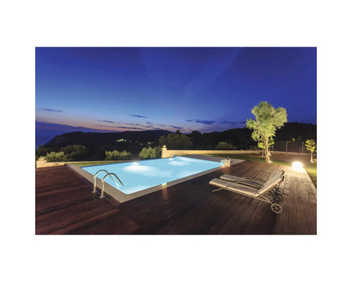 Beleuchteter Pool mit Holzdeck und Liegestuhl bei Dämmerung