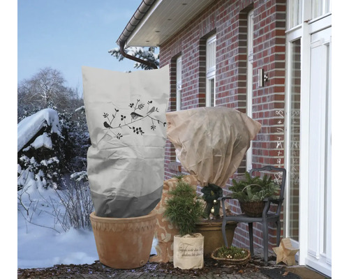Scène hivernale avec des plantes protégées du froid par des voiles d''hivernage et des sacs de protection hivernale.