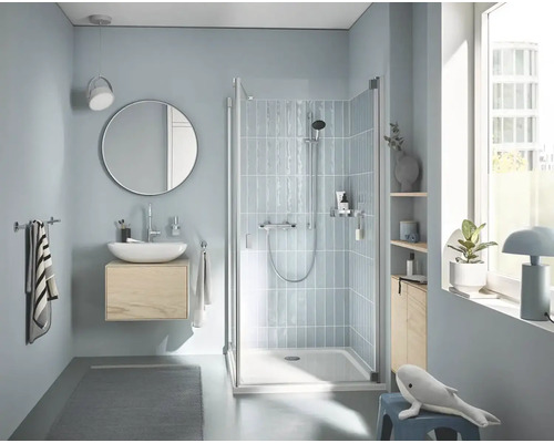 Helles Badezimmer mit Dusche, Waschbecken, Spiegel und Accessoires für ein entspannendes Ambiente.