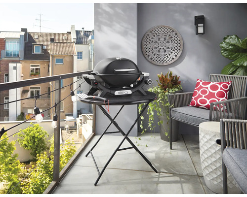 Balcon avec barbecue à gaz, sièges et éléments décoratifs pour une ambiance chaleureuse.