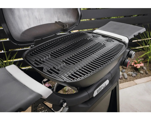 Barbecue Weber avec couvercle ouvert et grille.