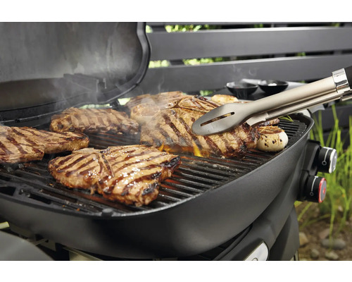 Barbecue avec steaks et pince à barbecue