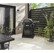 Extérieur avec barbecue sphérique, ustensiles de barbecue et table de jardin sur une terrasse
