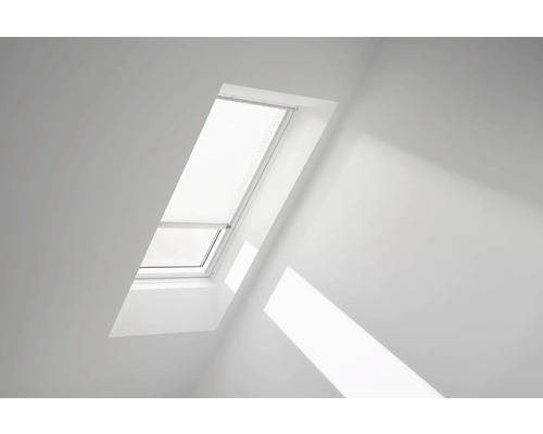 Fenêtre de toit avec store dans une pièce lumineuse.