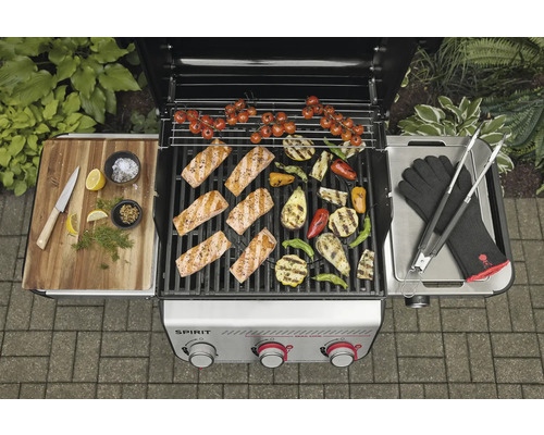 Scène de barbecue avec saumon, légumes et accessoires de barbecue sur un barbecue à gaz