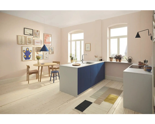 Helle und geräumige Küche mit Kücheninsel, Esstisch, Holzstühlen und verschiedenen Dekorationen.