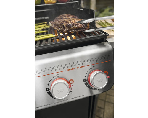 Grill avec steak et asperges sur la grille et commandes Sear Zone.